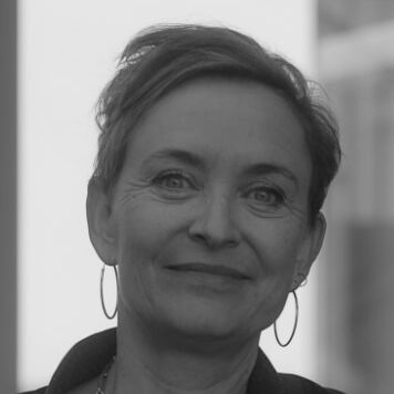 Portrætbillede af Christina Grøntved, administrerende direktør i Incita – Center for Autisme. Hun smiler venligt mod kameraet og har kort hår og øreringe.